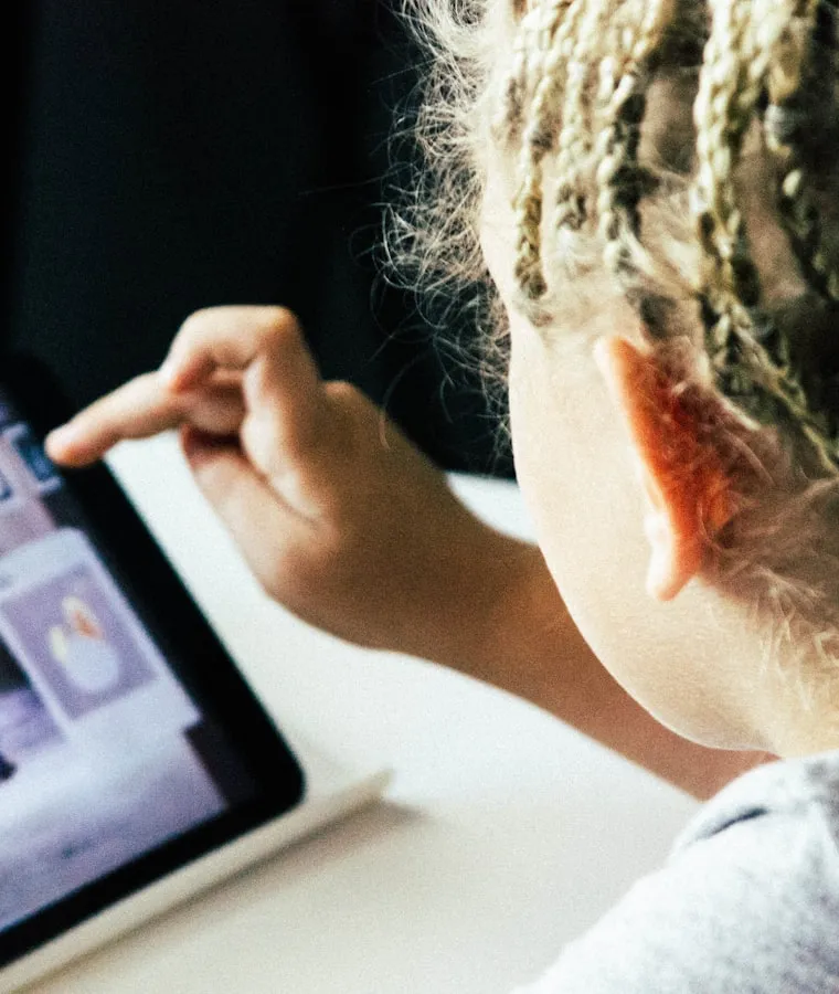 Child tapping an educational app on a tablet